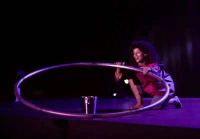 Tami con la rueda Cyr y un cubo de agua en escena.